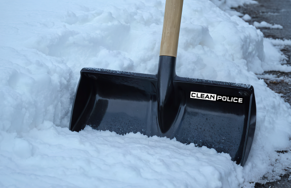 Clean Police Winterdienst Schaufel mit Holzgriff in frischem Schnee, bereit zum Schneeräumen.
